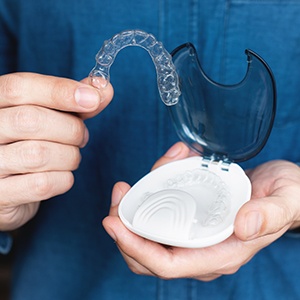 Person in blue shirt placing Invisalign into carrier case